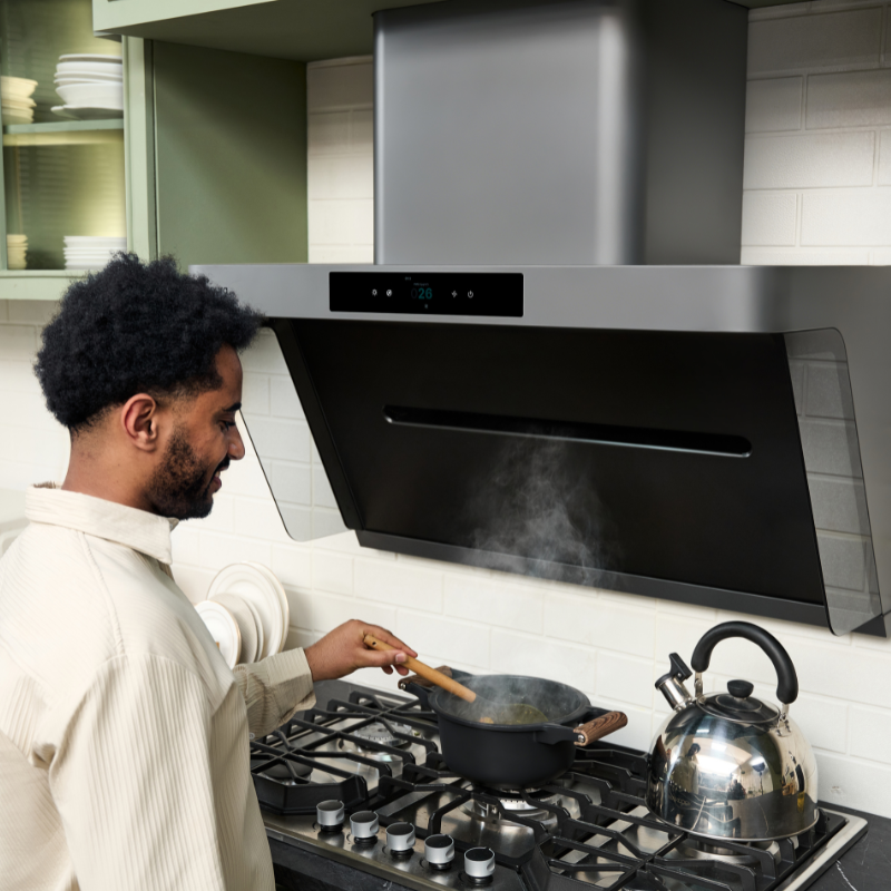 Man cooking under modern range hood for ventilation