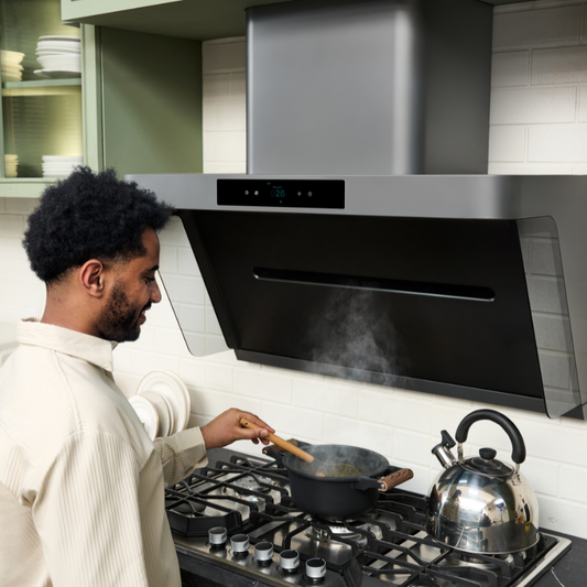 Man cooking under modern range hood for ventilation