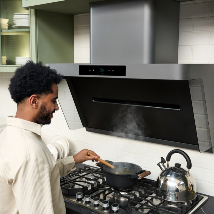 Man cooking under modern range hood for ventilation