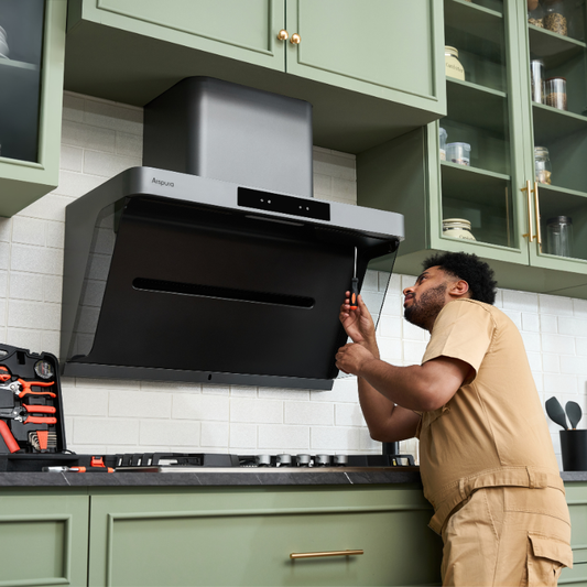 Technician installing or repairing an Arspura range hood in a modern kitchen