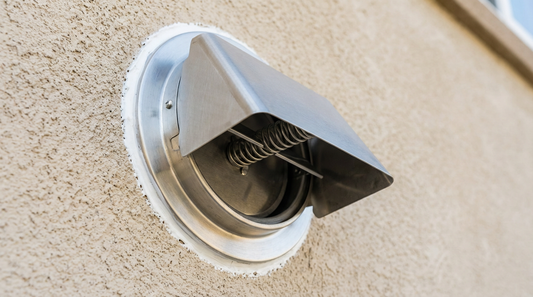 Stainless steel wall vent cap with backdraft damper installed on exterior wall