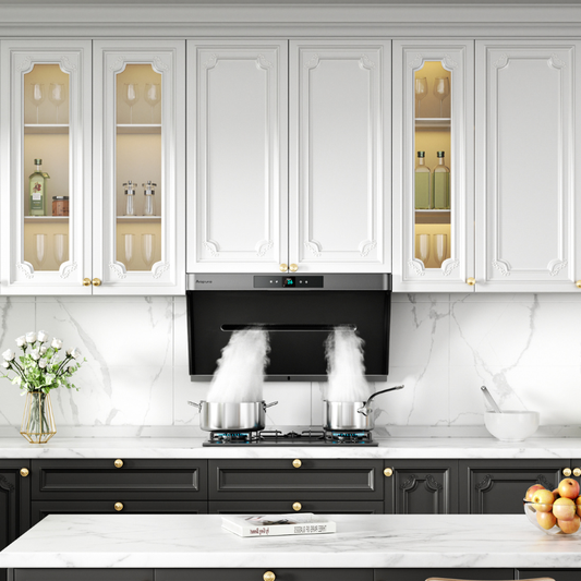 Close-up view of white traditional-style kitchen cabinets with decorative molding and glass-front doors displaying glassware, black wall-mounted range hood actively venting steam from two pots on a gas cooktop, marble backsplash, and white countertop